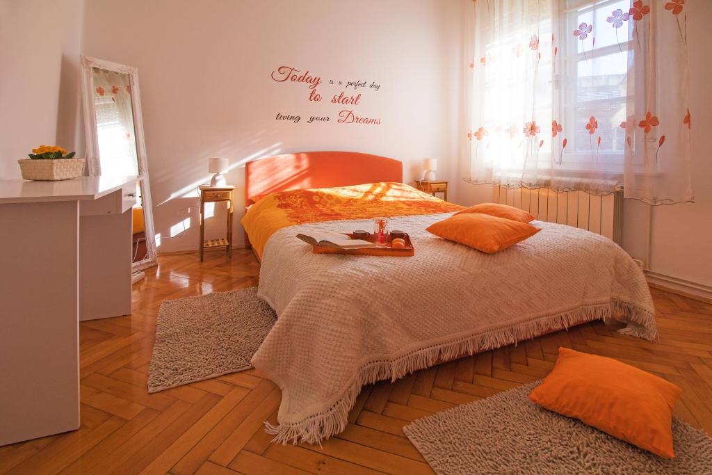 sypialnia z łóżkiem z pomarańczowymi poduszkami w obiekcie Arena Festival w Puli