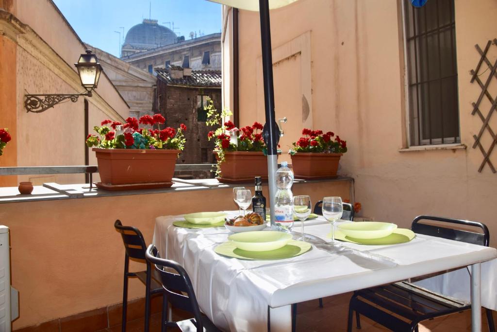 ローマにあるCuore di Roma Apartmentのバルコニーに白いテーブルクロス付きのテーブル