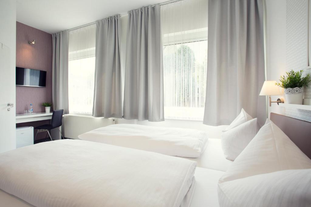 a hotel room with two beds and a desk at Hotel Löwenguth in Montabaur