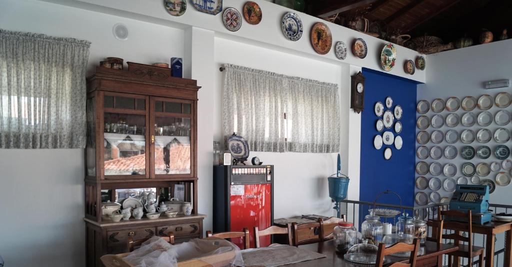 Quinta Manel da Gaita في توريس نوفاس: غرفة مع طاولة على الحائط مع لوحات