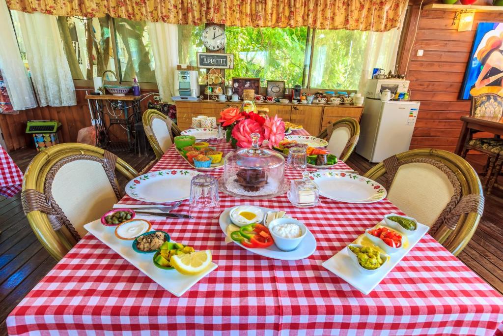a table with a red checkered table cloth with food on it at Betzel Ha'Ella in Kahal
