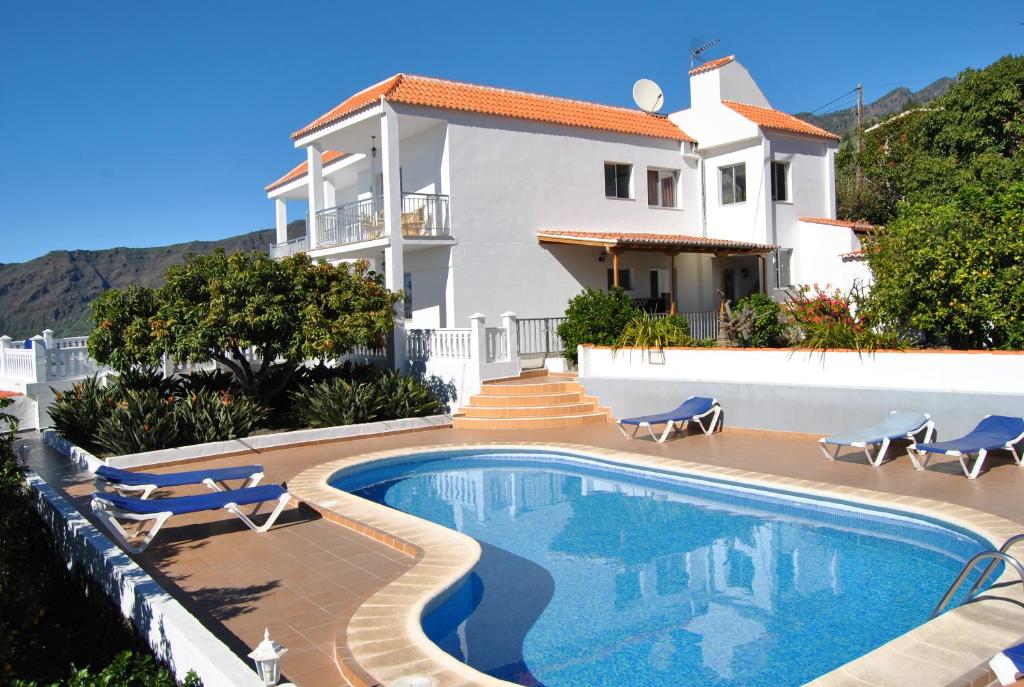 Villa con piscina frente a una casa en Casitas Rosheli, en Los Llanos de Aridane