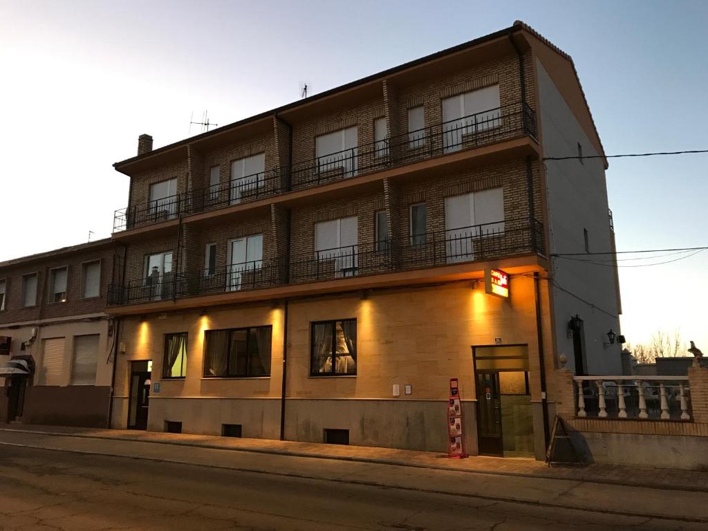 um edifício de apartamentos na esquina de uma rua em Hostal Juli em San Justo de la Vega