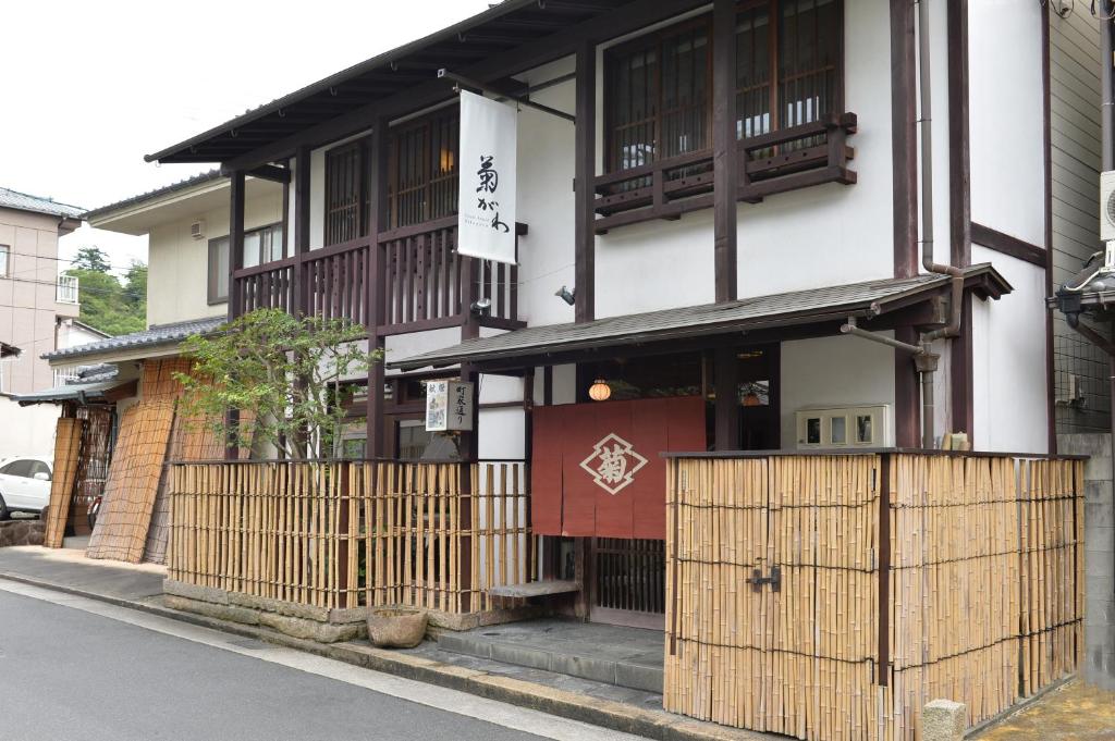 a building with a gate on the side of a street at Itsukushimahigashimonzen Kikugawa in Miyajima