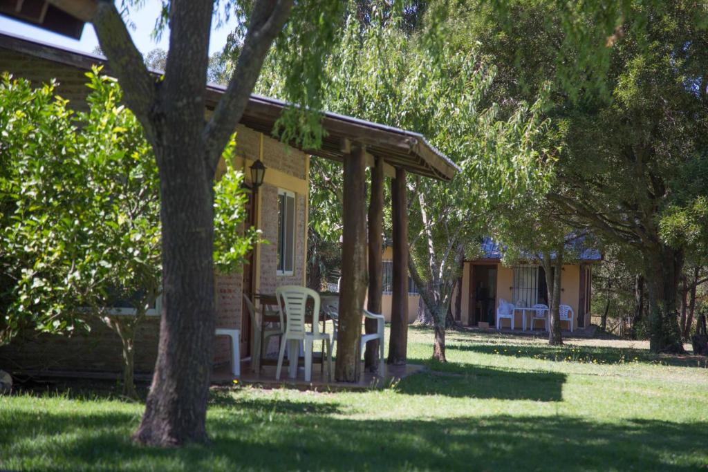 une maison avec des chaises et une terrasse couverte avec des arbres dans l'établissement La Posada del Mar, à Miramar