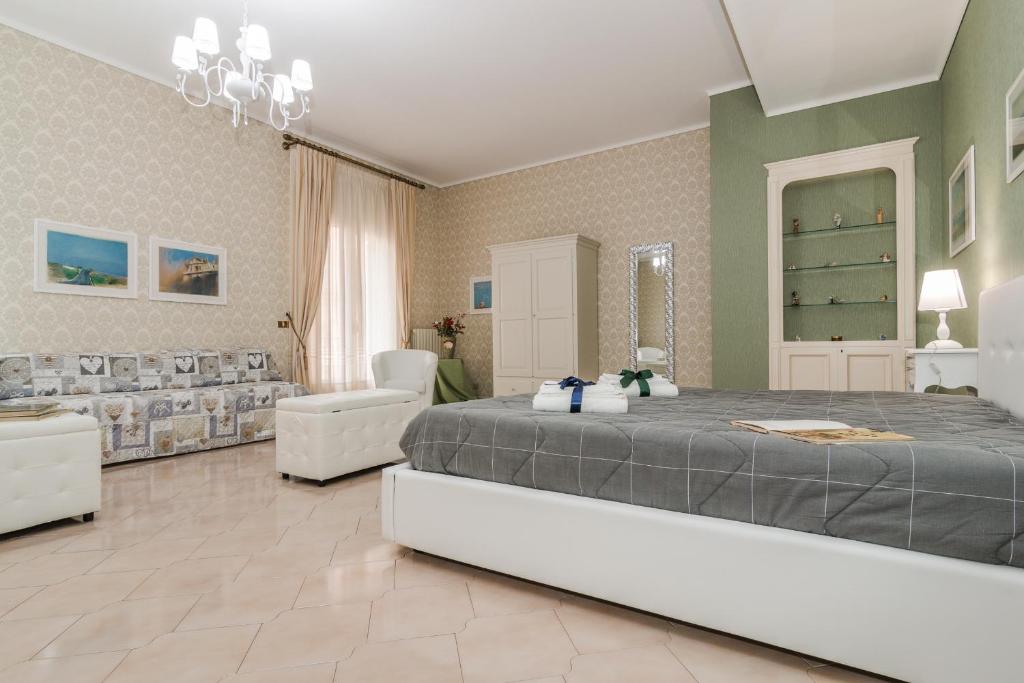 ein großes Schlafzimmer mit einem großen Bett und Stühlen in der Unterkunft Vivi La Contea in Modica