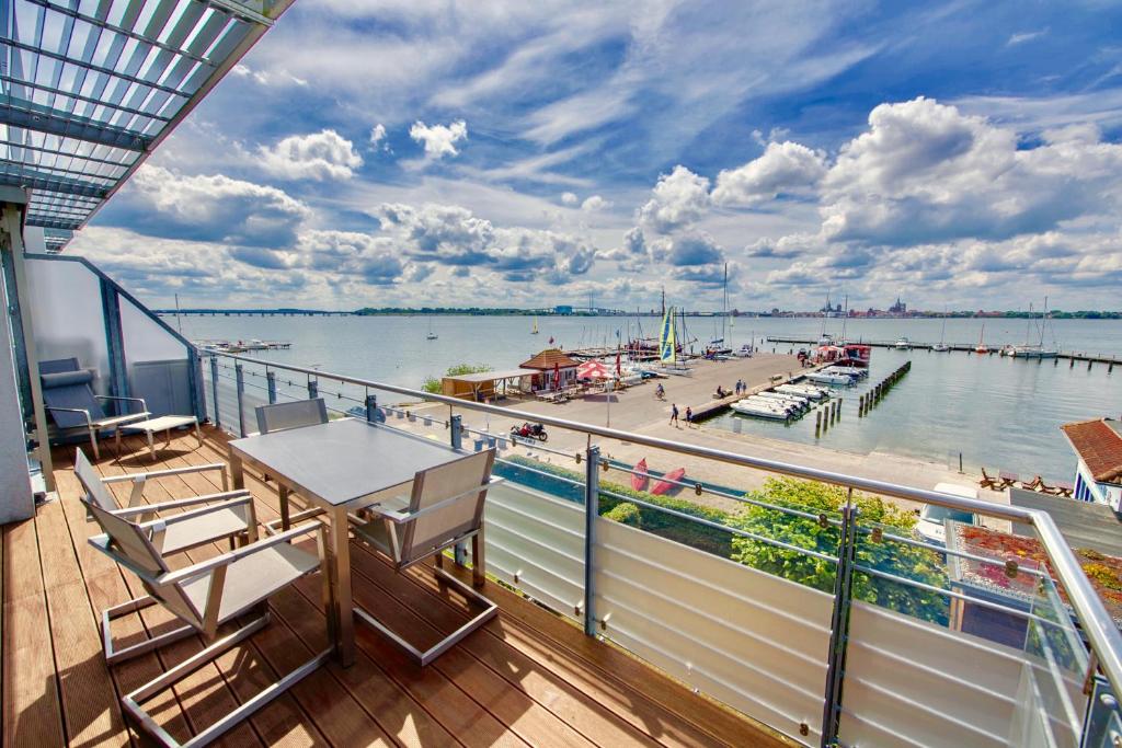 balcón con mesa y sillas y puerto deportivo en Haus Putbus - Ferienwohnung 7 "Southwest beach", en Altefähr