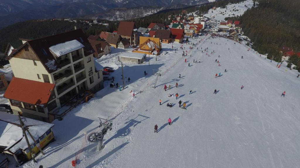 a group of people skiing down a snow covered slope at Pensiune Restaurant TERRA in Ranca
