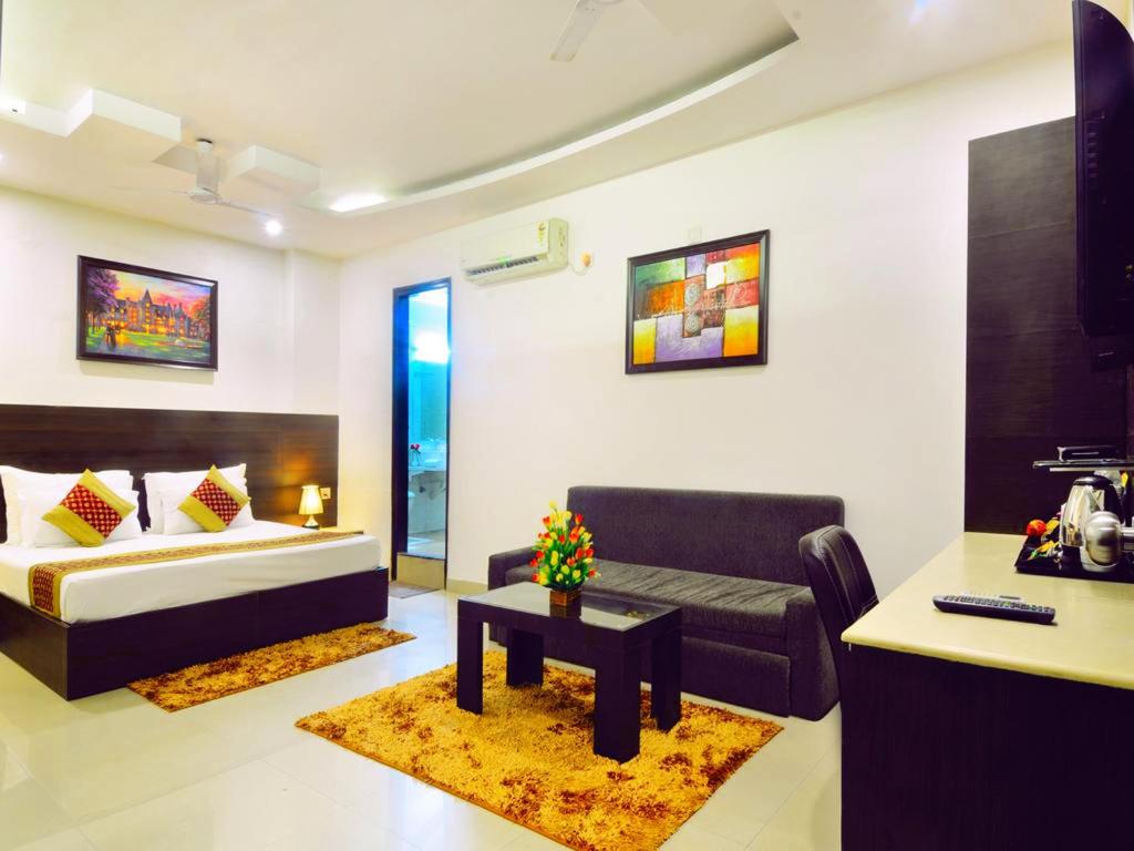 a hotel room with a bed and a couch and a table at Hotel Sky Rich International - 05 Mins from Karol Bagh Metro Station in New Delhi