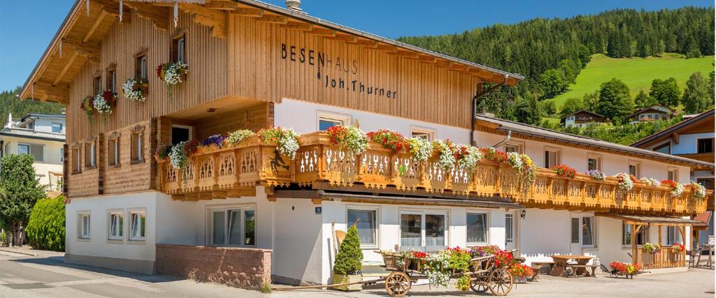 a building with a balcony with flowers on it at Alpenhostel "Das Besenhaus" in Altenmarkt im Pongau
