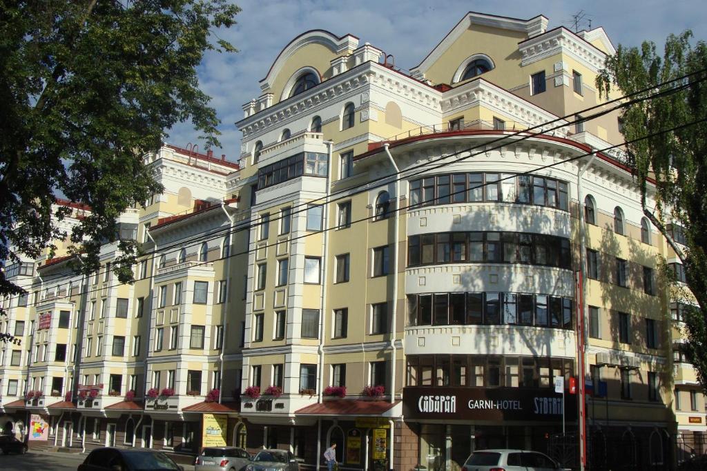 un gran edificio blanco en una calle de la ciudad en Garni Hotel Sibiria, en Perm