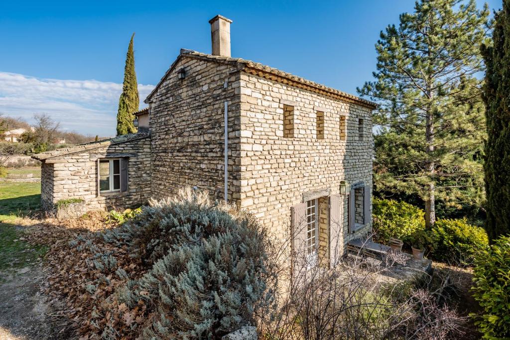 an old brick house with a chimney on top of it at La Maison des Roches in Gordes