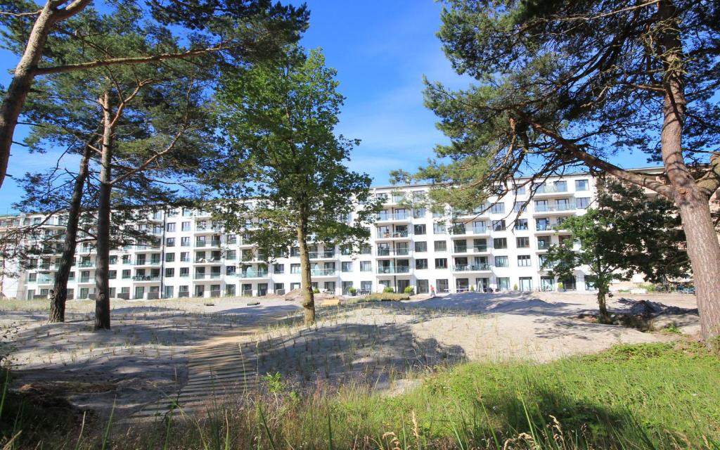 ein großes weißes Gebäude mit Bäumen davor in der Unterkunft Meersinfonie Binzprora by Rujana in Binz