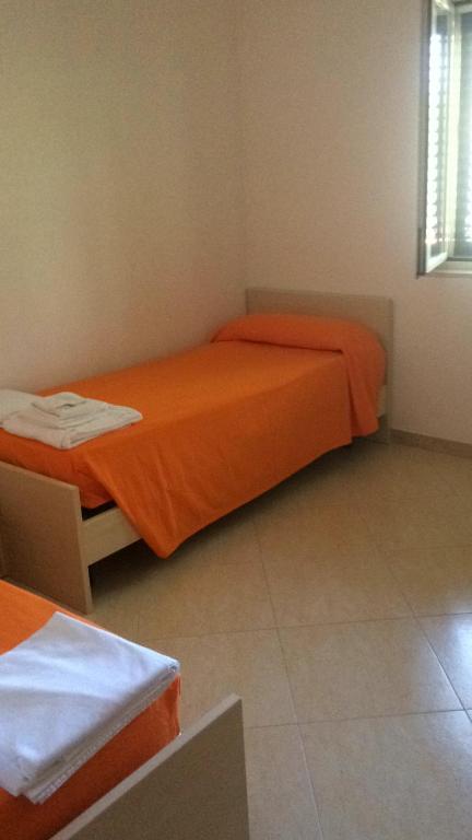 ヴィエステにあるCasa aleのベッドルーム1室(オレンジのシーツを使用したベッド2台付)
