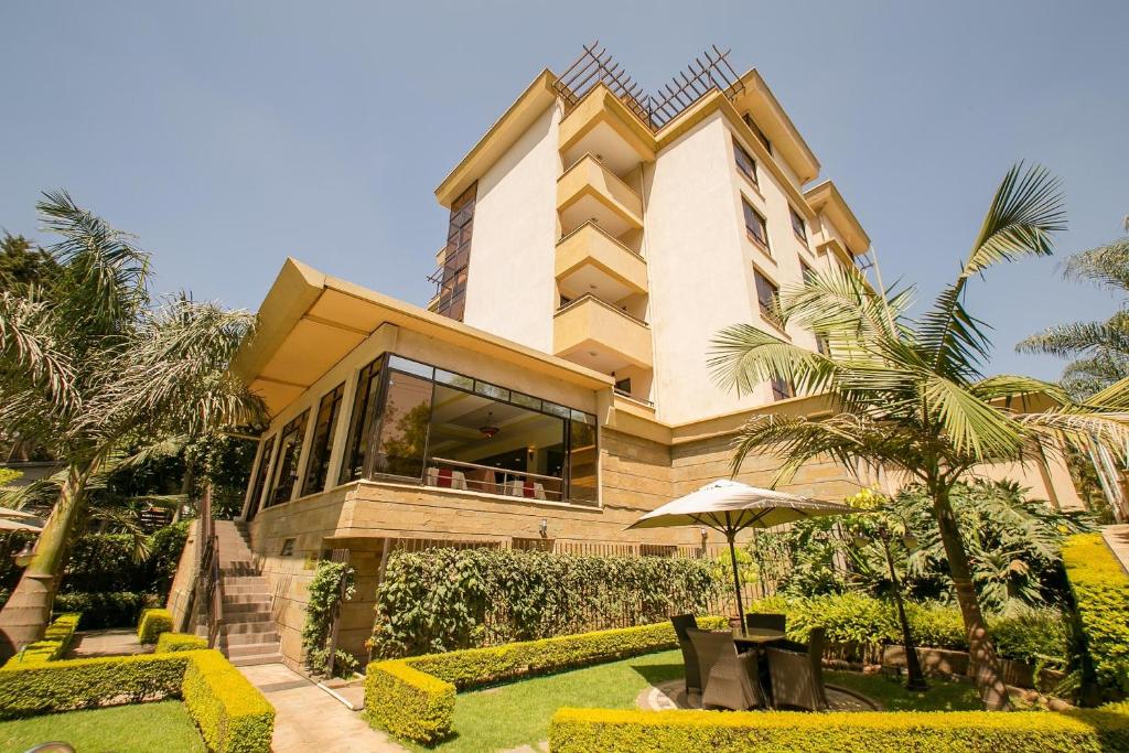 a large building with a garden in front of it at Waridi Paradise Hotel and Suites in Nairobi