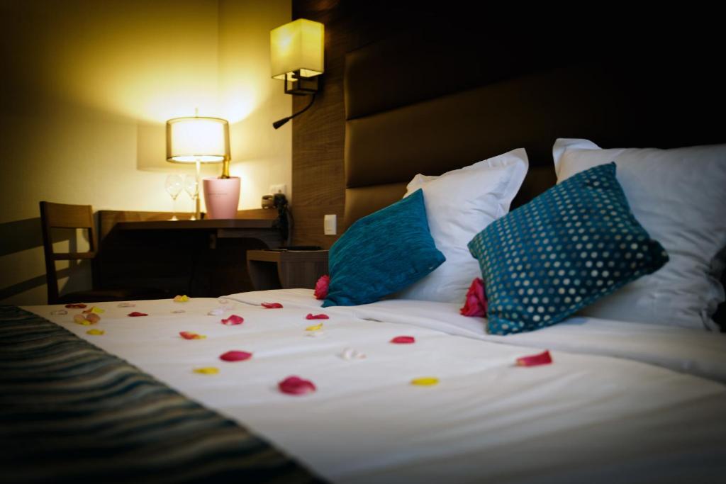 a bed with flowers on it with a lamp and a table at Logis Auberge Des Moissons in Matougues