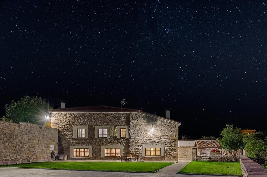una casa de piedra por la noche con un cielo estrellado en La Casa De Los Pedros, en Villar