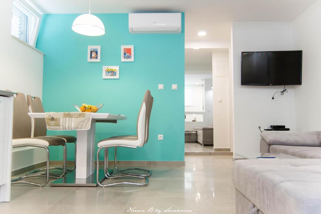 uma sala de estar com uma parede azul e uma mesa e cadeiras em S&S SPLIT APARTMENT em Split