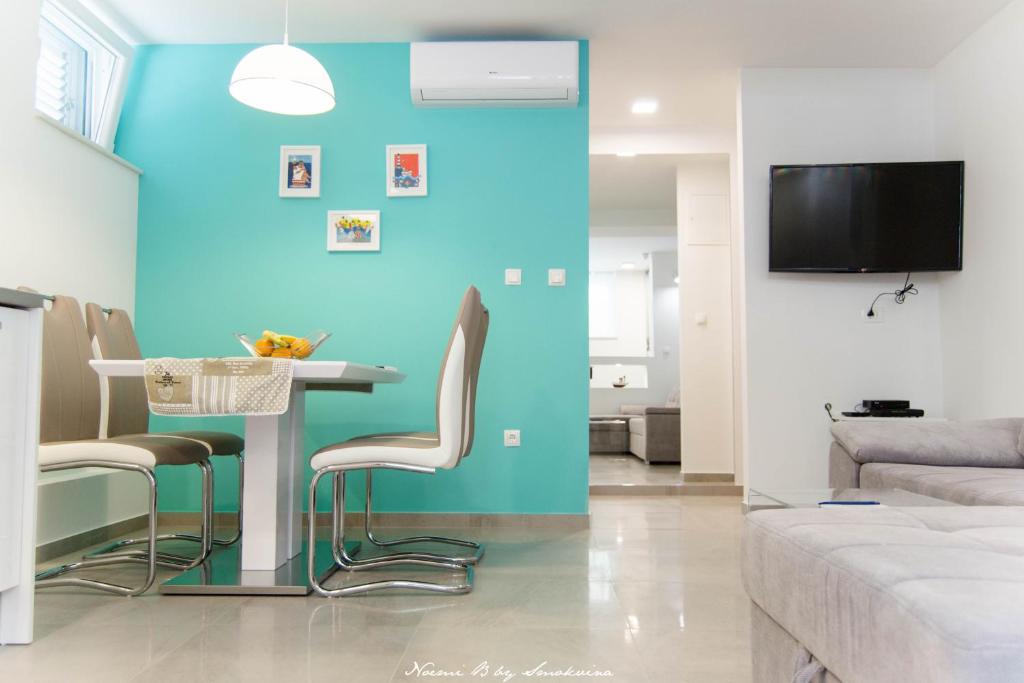 a living room with a blue wall and a table and chairs at S&S SPLIT APARTMENT in Split