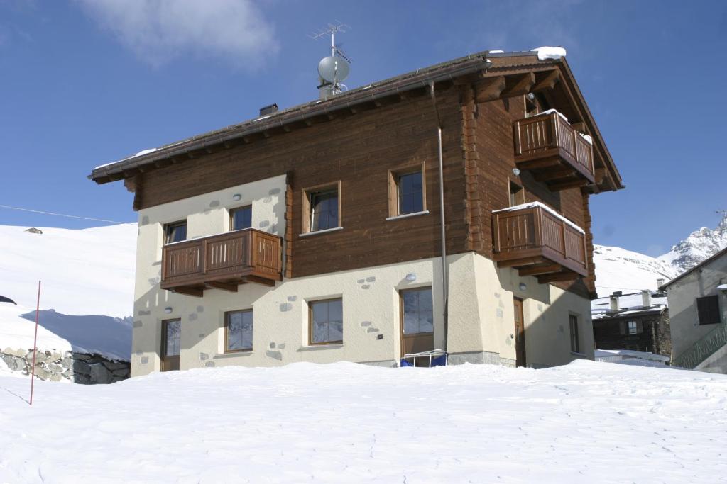 ein Gebäude mit Balkon im Schnee in der Unterkunft Chalet Li Baita Daniela in Livigno