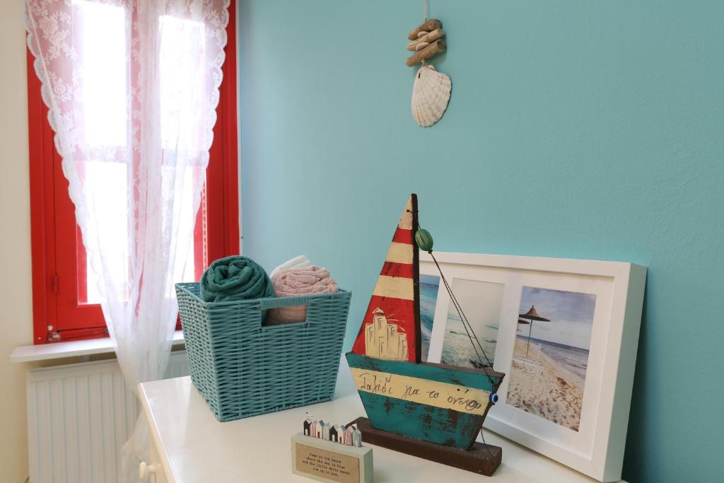 Un estante con un barco de juguete y un cuadro. en Protaras Happy Sunny Holidays, en Paralimni