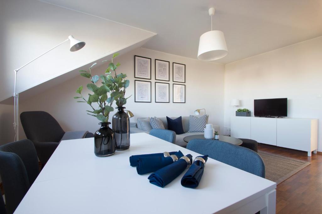 einen weißen Tisch mit blauen Stühlen und ein Wohnzimmer in der Unterkunft Capital Flat 70m2 in Luxemburg (Stadt)