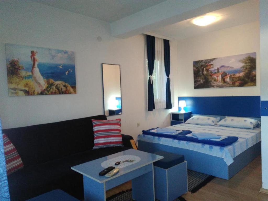 ein kleines Zimmer mit einem Bett und einem Sofa in der Unterkunft Blue Apartments & Suites in Ohrid