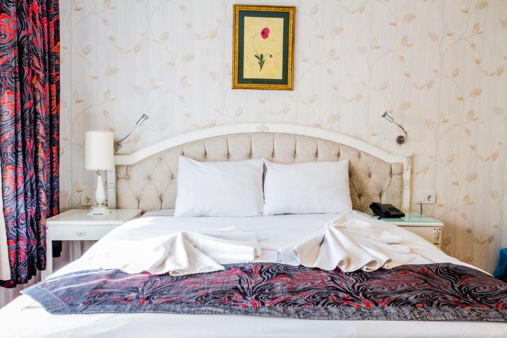 1 dormitorio con cama blanca y cabecero blanco en elisa hotel, en Estambul