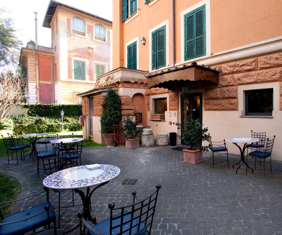 a patio with tables and chairs in front of a building at Hotel Aventino in Rome