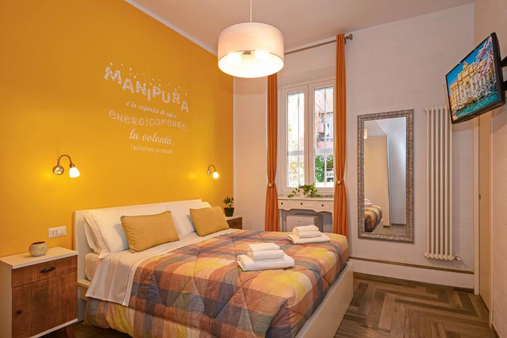 a bedroom with a bed with a yellow wall at Allegra's House Caracciolo in Rome