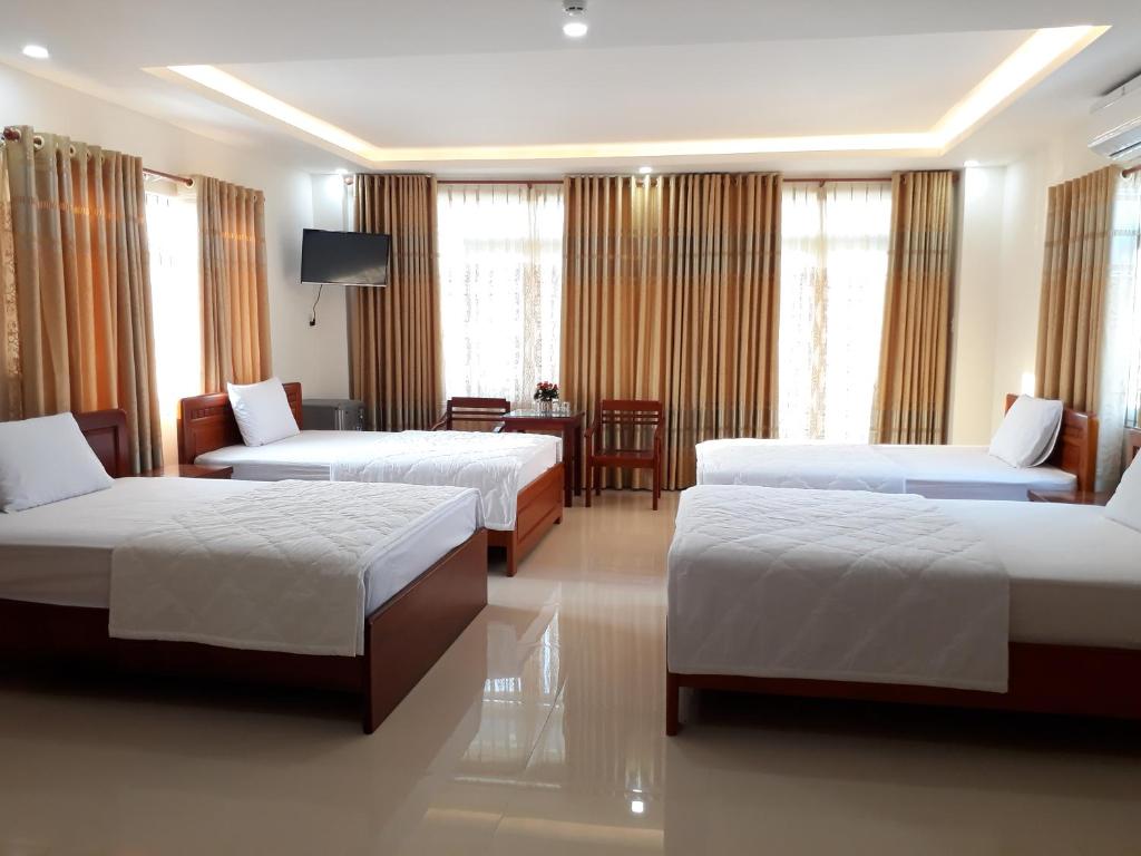 Cette chambre comprend 2 lits et une table. dans l'établissement DUY HUY hotel & apartment, à Nha Trang