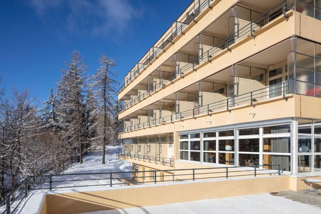 a hotel in the winter with snow on the ground at Crans-Montana Youth Hostel in Crans-Montana
