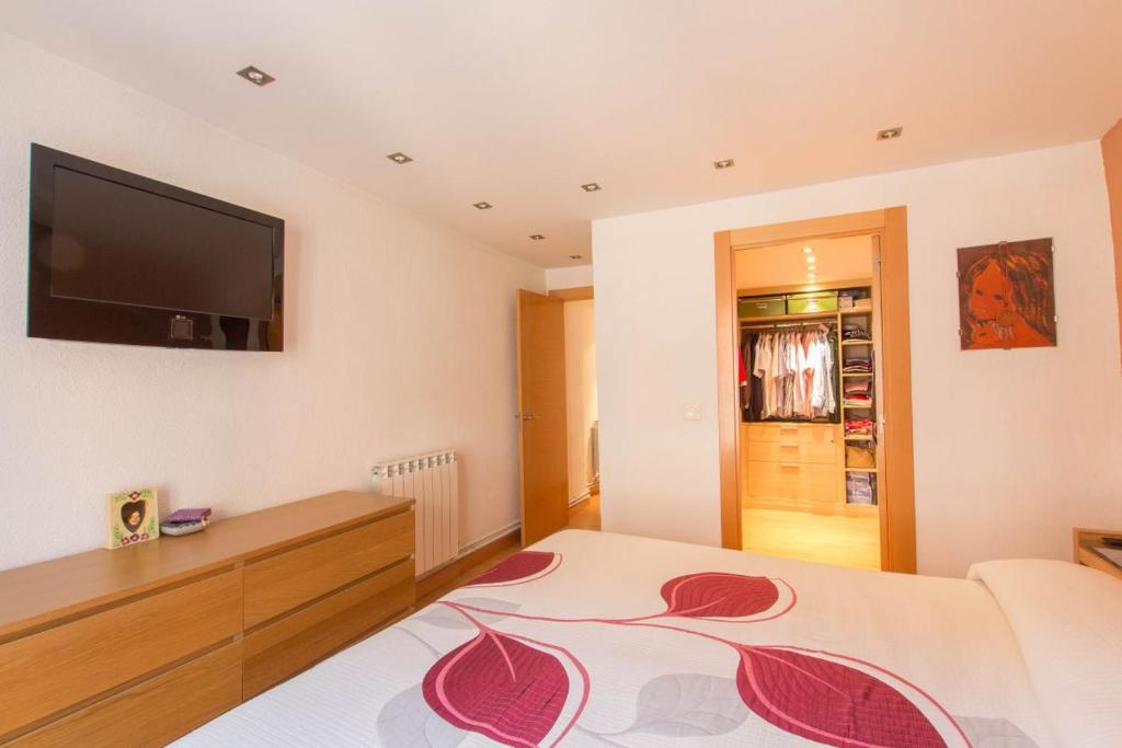 a bedroom with a bed and a flat screen tv at En el Centro de Pamplona, La Taconera in Pamplona