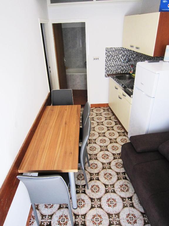 a small kitchen with a wooden table and chairs at Apartment old town in Primošten