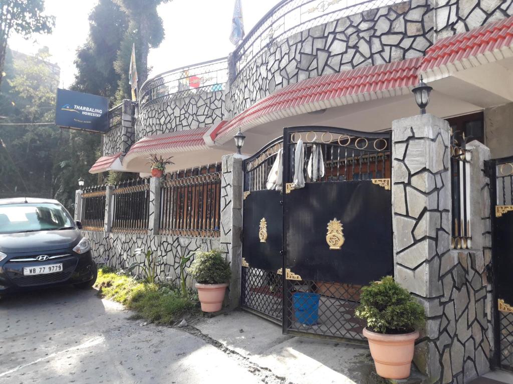 a car parked in front of a house with a gate at Tharbaling HomeStay in Darjeeling