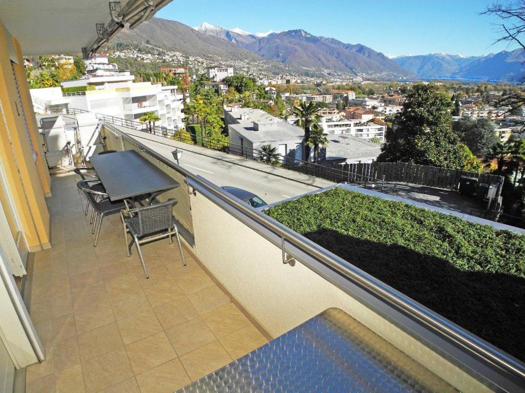 een balkon met een tafel en stoelen en uitzicht op de stad bij Casa Dodi App 2526 in Ascona