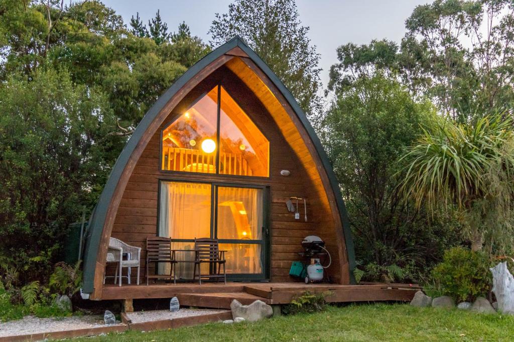 une petite cabane dans les arbres avec une grande fenêtre dans l'établissement Wetland View Park, à Anatori