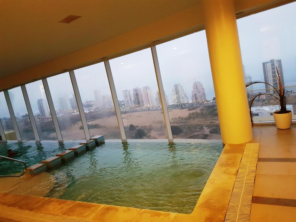 a swimming pool in a building with a view of a city at Departamento Full en Reñaca-Concon in Viña del Mar