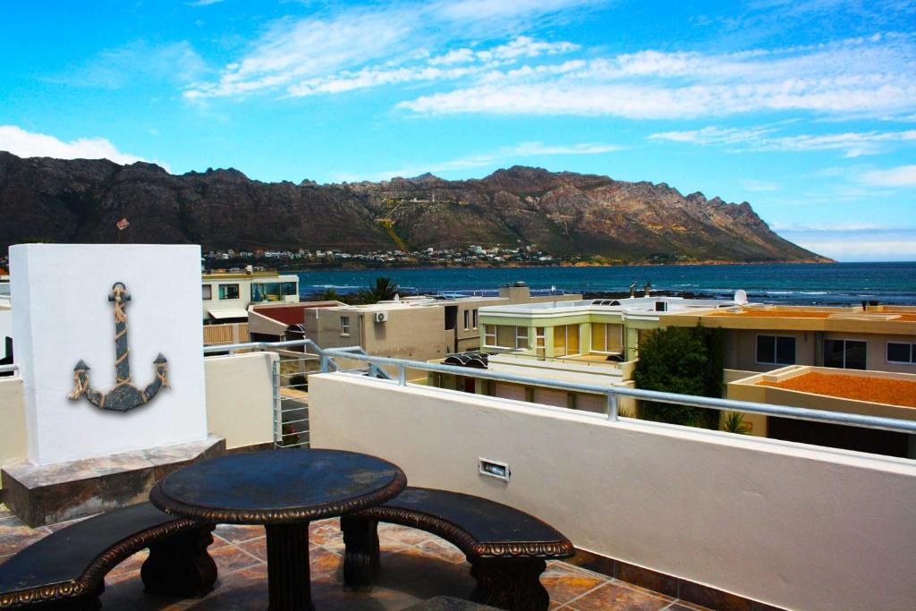 a table on a balcony with a view of the ocean at 20 Cayman Beach, Gordon's Bay in Gordonʼs Bay