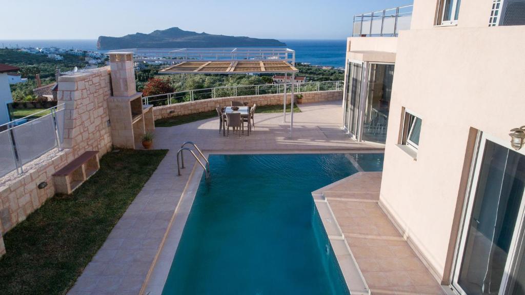 a swimming pool in the backyard of a house at Pantanassa Villa Thalia in Agia Marina Nea Kydonias