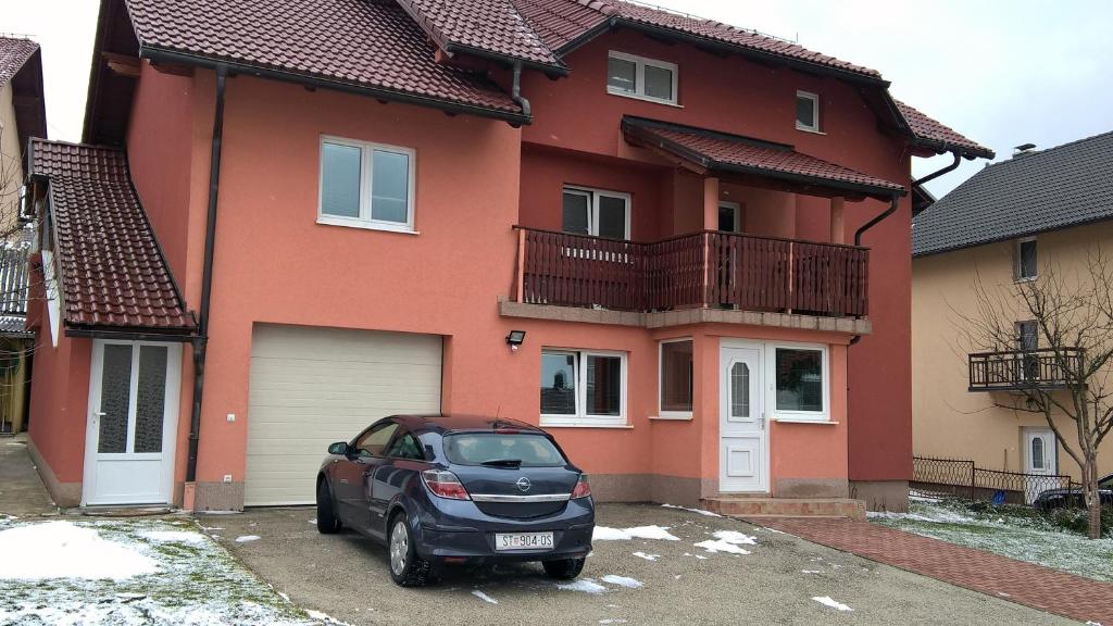 a car parked in front of a house at Apartman Vesna in Kupres