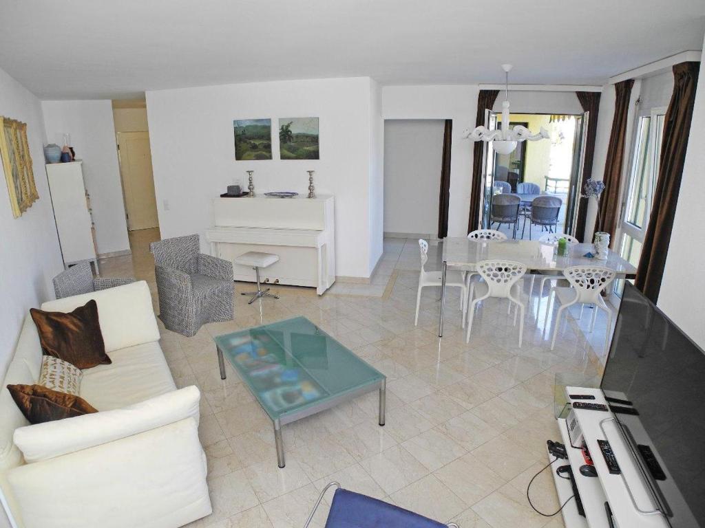 salon z białą kanapą i stołem w obiekcie Casa Robinia App 4000 w mieście Locarno