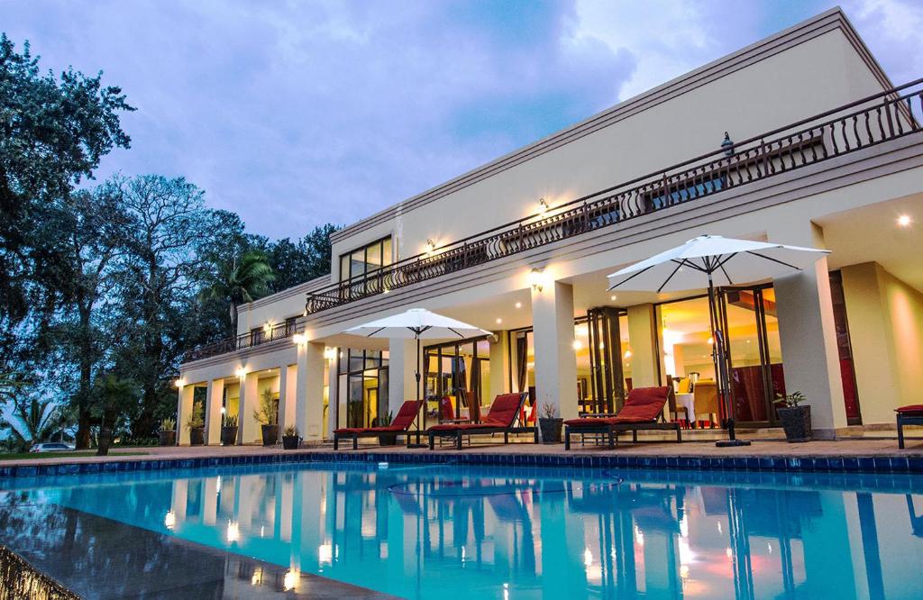 une maison avec une piscine en face de celle-ci dans l'établissement Ebandla Hotel & Conference Centre, à Ballito