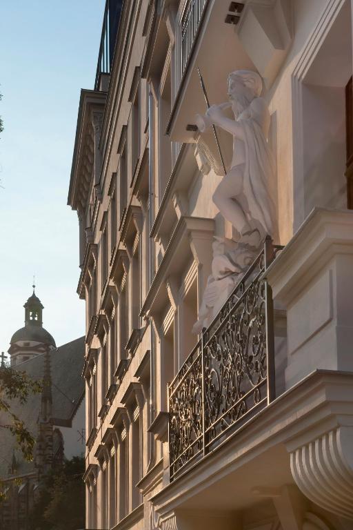 a statue of a woman on the balcony of a building at INNSiDE by Meliá Leipzig in Leipzig