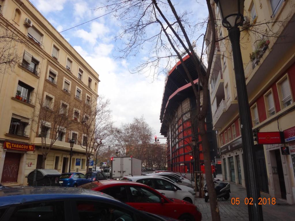 eine Stadtstraße mit parkenden Autos und Gebäuden in der Unterkunft Una Ubicacion Perfecta in Valencia