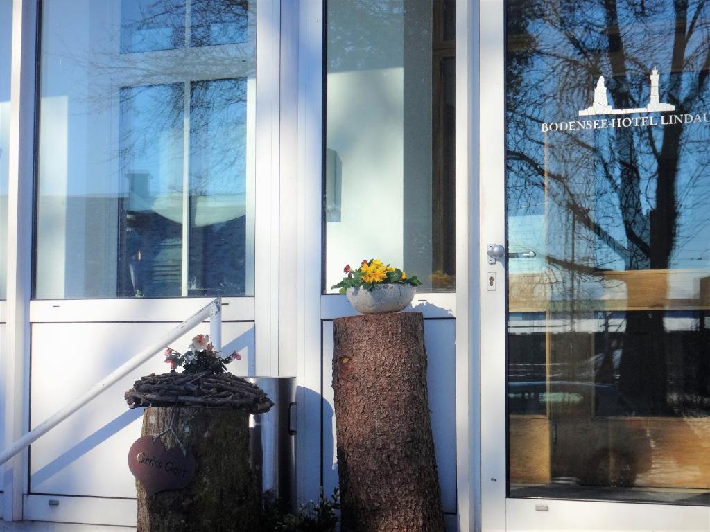 a door of a building with two pillars with flowers on them at Bodenseehotel Lindau in Lindau