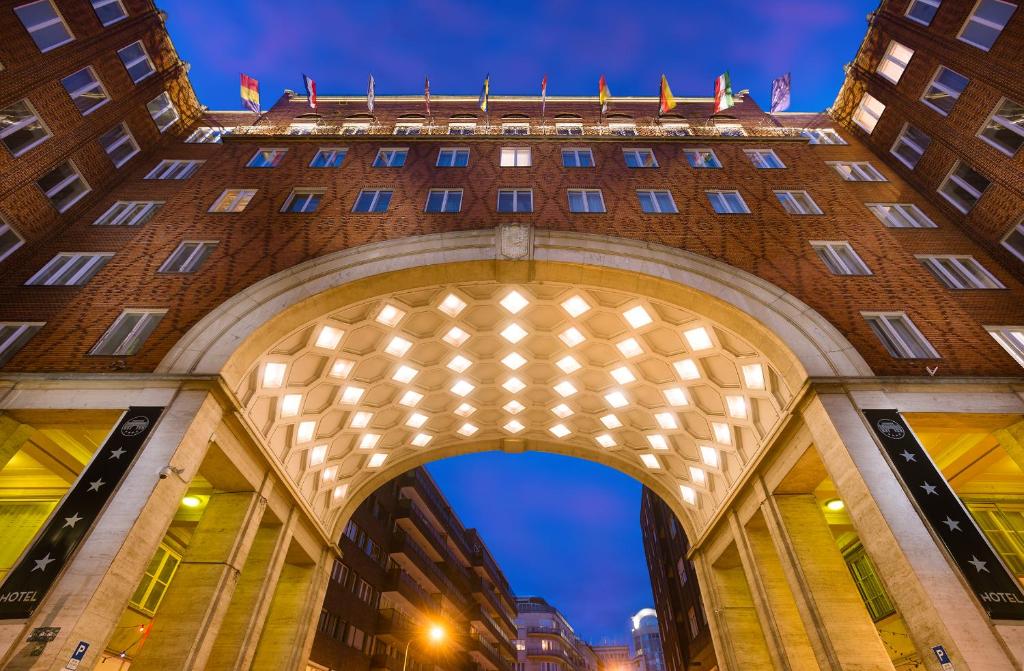 a building with an arch at night at Arcadia Hotel Budapest in Budapest