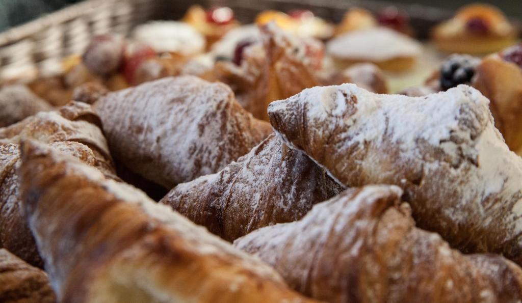 una pila de pasteles con azúcar en polvo. en Spluga Sosta & Hotel, en Dubino