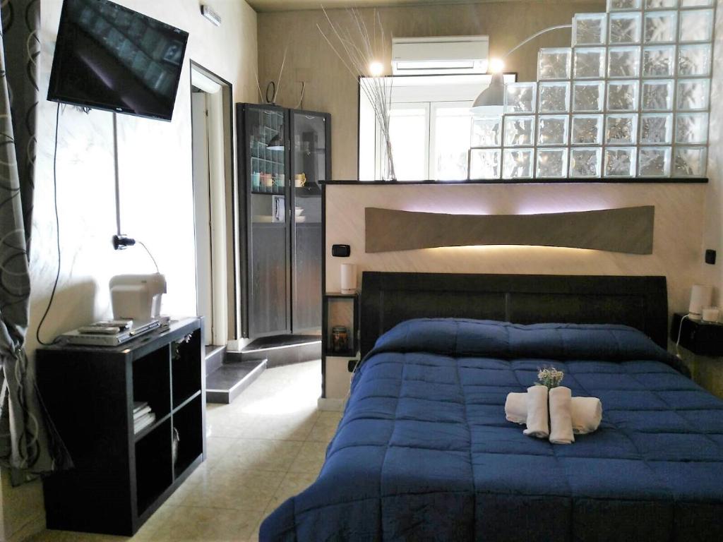 a bedroom with a blue bed with two white towels at Casa Tua a Piazza del Popolo in Rome