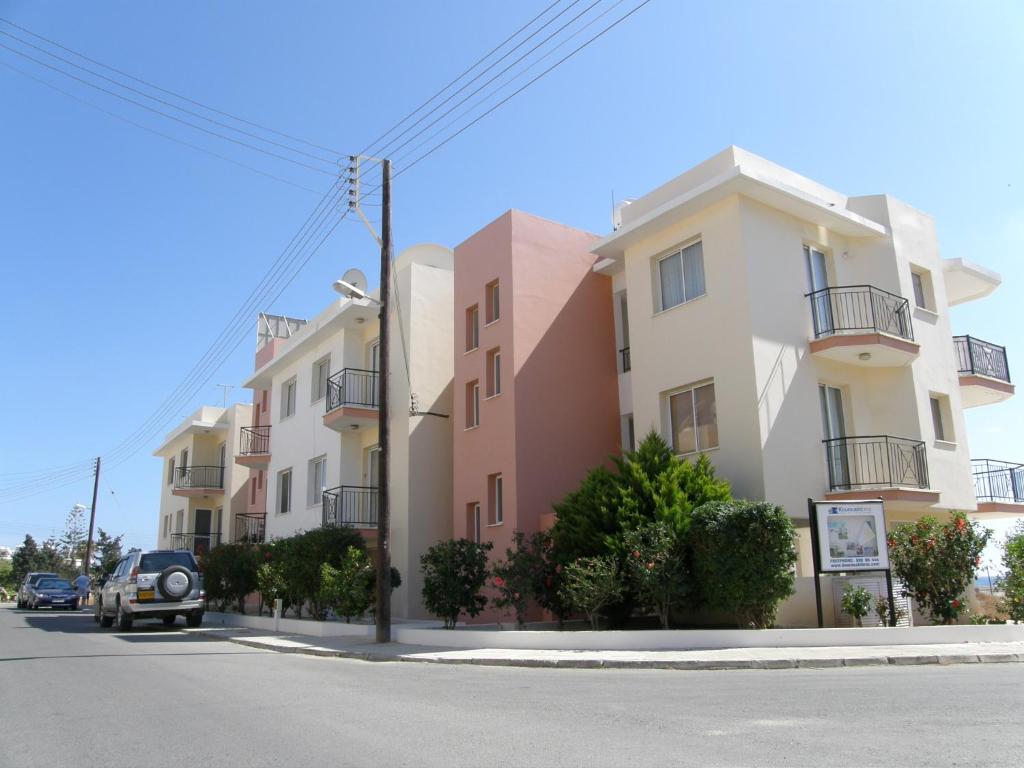 um carro estacionado em frente a uma fila de edifícios em Athena and The Owl Beachside Apt em Pafos